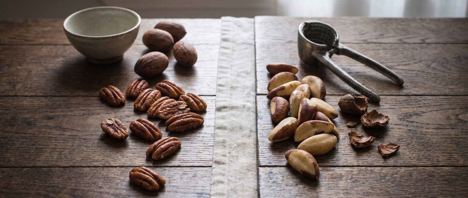 Noix de pécan et noix du Brésil présentées sur une table en bois